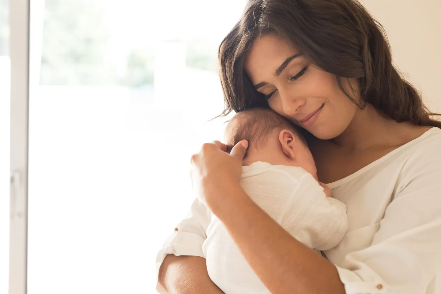 Mama hält ihr Baby in warmem Morgenlicht